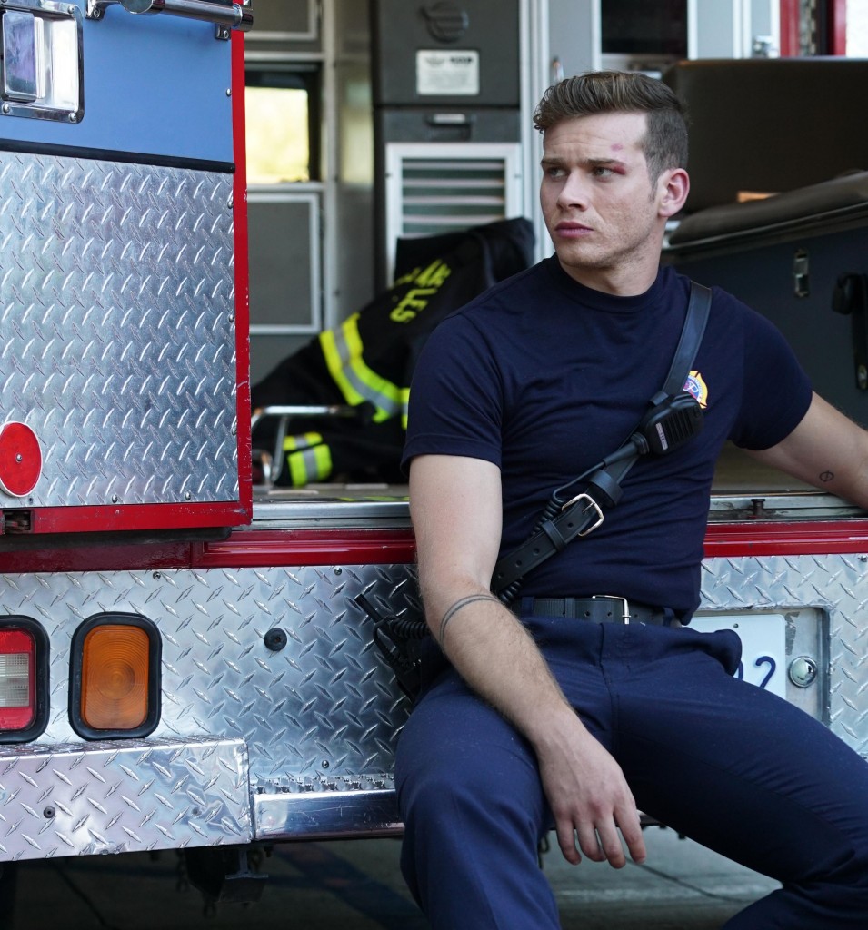Le pompier Evan Buckley, dit simplement Buck (Oliver Stark) attend sur le parvis de l'ambulance sagement.