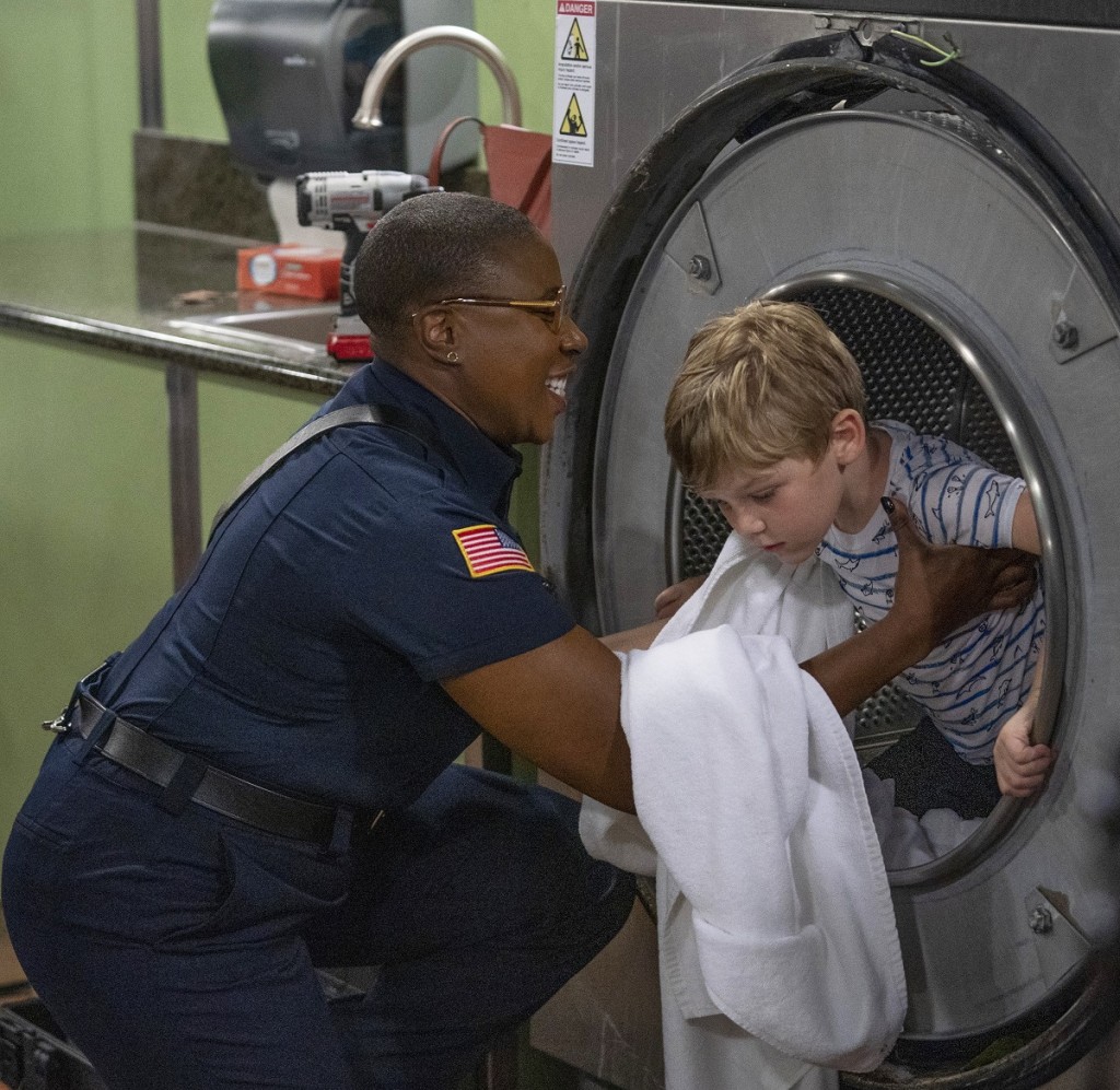 Hen Wilson sort un jeune enfant d’une machine à laver.