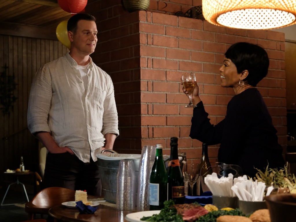 Athena (Bassett) et Bobby (Peter Krause), son mari rigolent et boivent un verre de vin dans la cuisine.