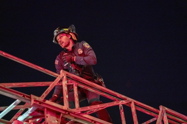En pleine intervention, Eddie Diaz (Ryan Guzman) monte par l'échelle du camion afin de sauver une personne qui a besoin de son aide.