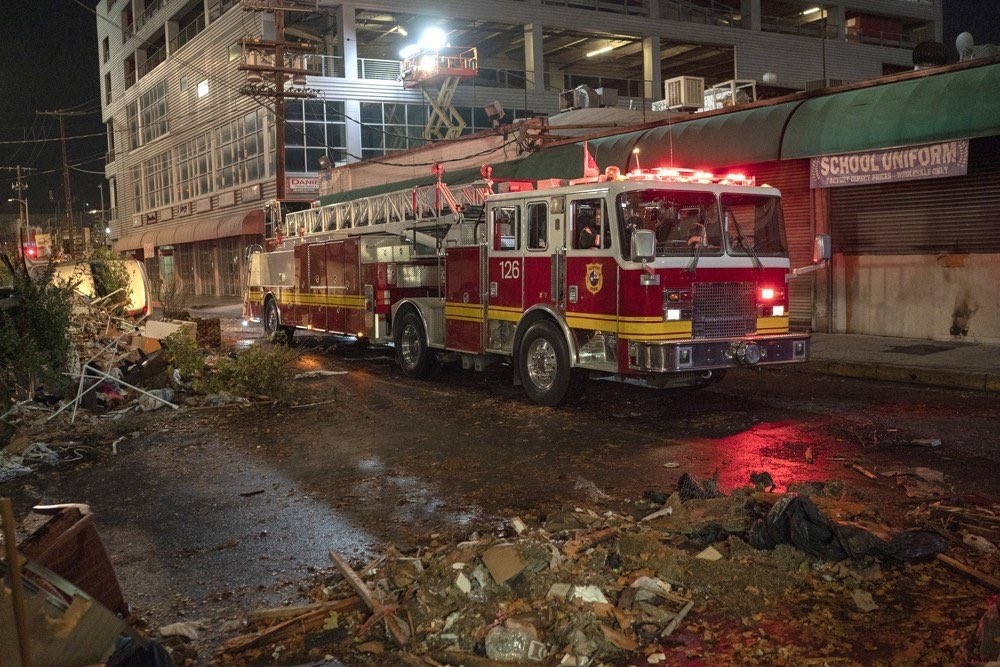 Un camion de pompiers se trouve en plein milieu de nombreux débris.