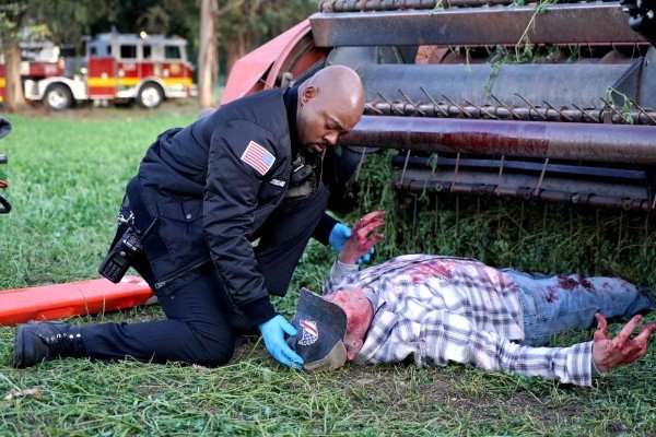 Le pompier Paul Strickland (Brian Michael Smith) aide une pauvre victime.
