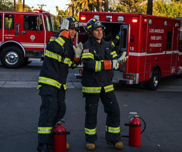 Les pompiers Evan Buckley dit Buck (Oliver Stark) et Eddie Diaz (Ryan Guzman) s'apprêtent à intervenir pour éteindre un incendie.