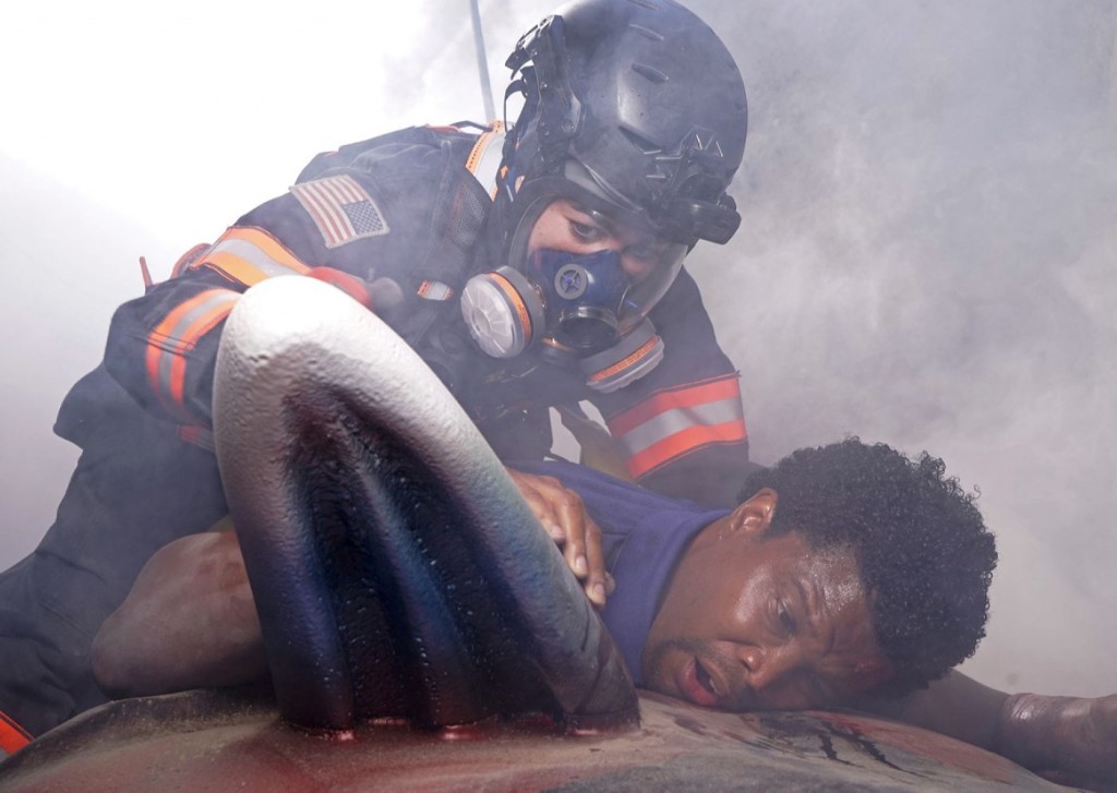 La pompière Marjan Marwani aide un jeune homme qui est blessé couché sur le sol.