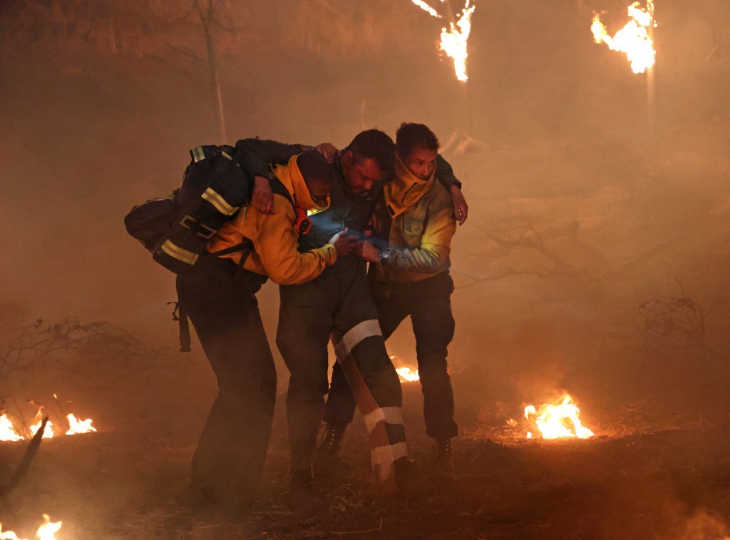 Hen Wilson (Aisha Hinds) et Owen Strand (Rob Lowe) portent à bout de bras une personne coincée dans l'incendie pour la mettre à l'abris loin de la forêt en feu.