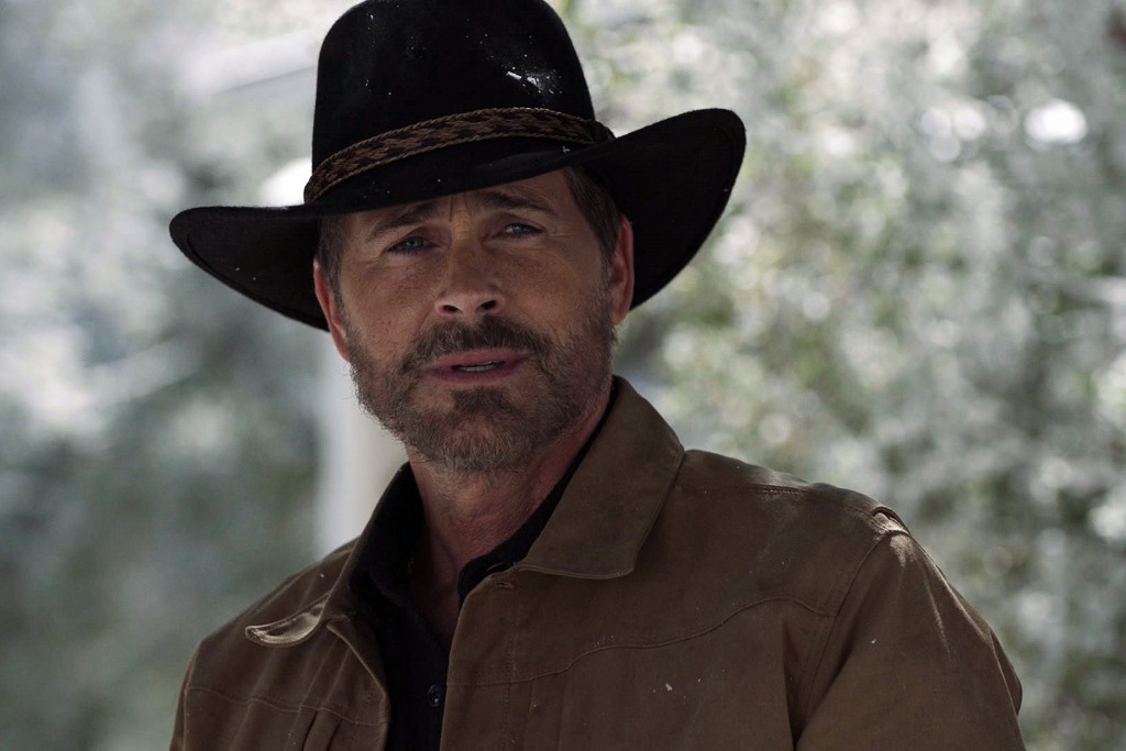 Owen (Rob Lowe) porte un chapeau de cowboy sur la tête.